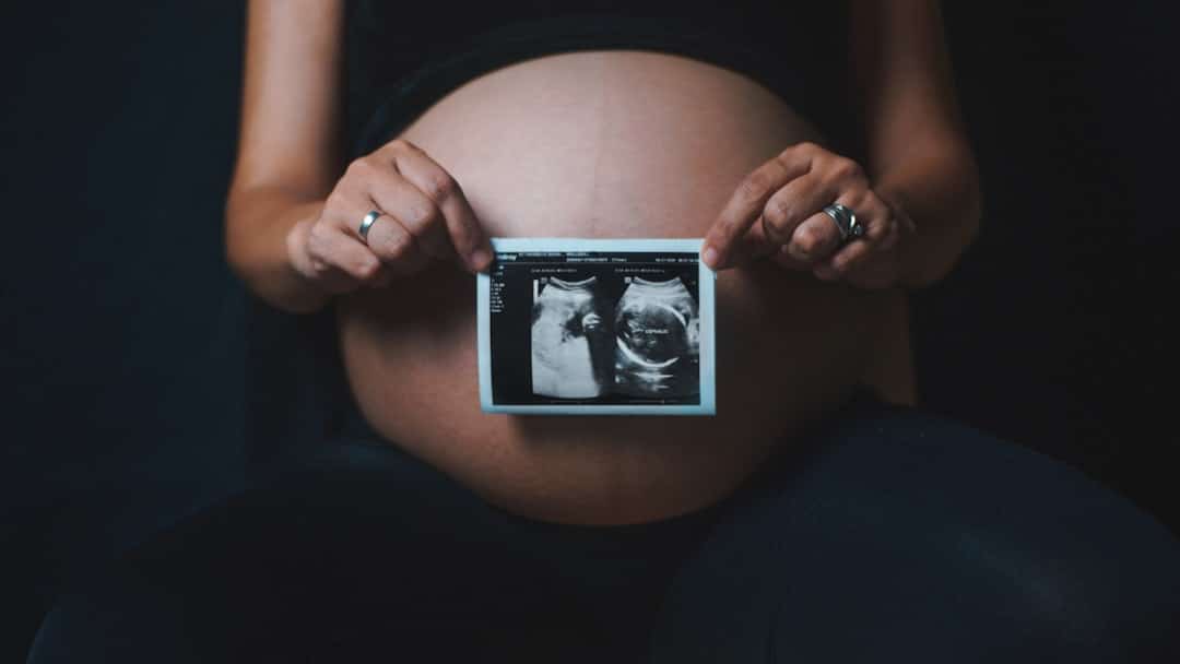a-pregnant-woman-holding-a-camera-in-her-hands-pqfyq0iur-u