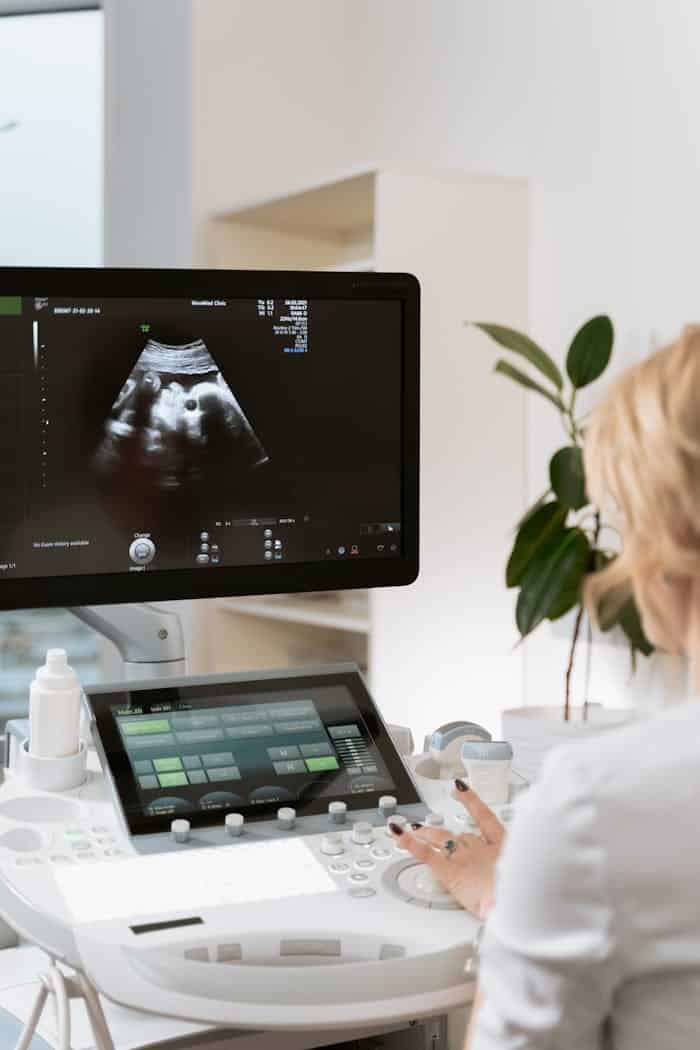 Medical professional using ultrasound equipment for patient diagnosis in a clinic.